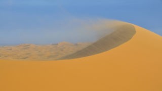 Wind verwehr den Sand auf einer Wüstendüne in Marokko
