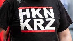 Ein Teilnehmer des Marsches der rechtsextremen Partei "Die Rechte" trägt ein T-Shirt mit der Aufschrift "HKNKRZ".