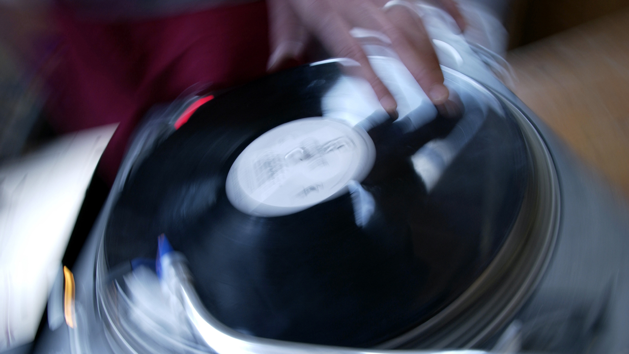 Ein Plattenspieler wird bei einer Hip Hop Veranstaltung durch einen DJ beim Scratching stark in Anspruch genommen