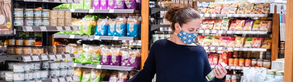 Eine Frau beim Einkaufen trägt einen selbstgemachten Mundschutz