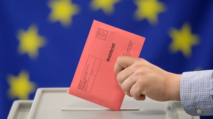 Ruka ubacuje koverat sa glasovima u izbornu kutiju