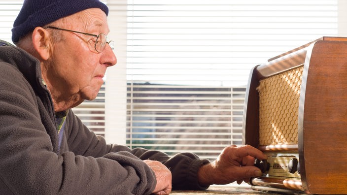 Stariji čovek sa starim radio aparatom