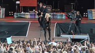 Sarah Connor und ihre Gitarristen spielend auf einem Steg, der ins Publikum führt