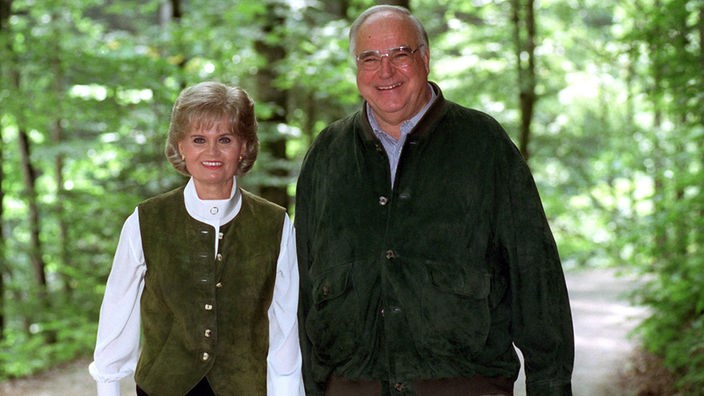 Hannlore und Helmut Kohl lächelnd auf einem Waldweg