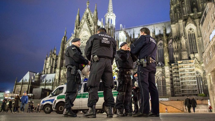 Polizisten stehen in Köln vor dem Hauptbahnhof neben dem Kölner Dom