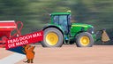 Ein Traktor zieht eine Drillmaschine über einen Acker und bringt Saatgut ein.