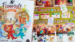 Die Spieleschachtel von Flamecraft zeigt den Titel des Spiels und drei bunte, niedliche Drachen. Daneben zeigt der Spielplan eine Stadt mit verschiedenen Läden, in denen kleine Drachen ihrer Arbeit nachgehen.