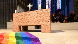 Regenbogenfahne vor einem Altar