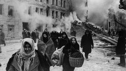 Leningrad im 2. Weltkrieg: Bewohner mit Gepäck vor den Trümmern ihrer Häuser. 