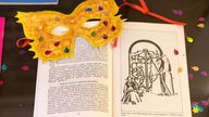 Eine bunte Maske liegt auf einem aufgeschlagenen Buch mit der Geschichte von Esther