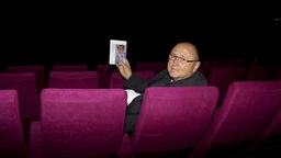 Filmemacher Christoph Böll, der über die Lehne eines Kino-Sessels blickt.