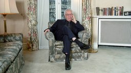 Archivaufnahme von 2001: Schriftsteller Johannes Mario Simmel sitzt in einem Sessel.