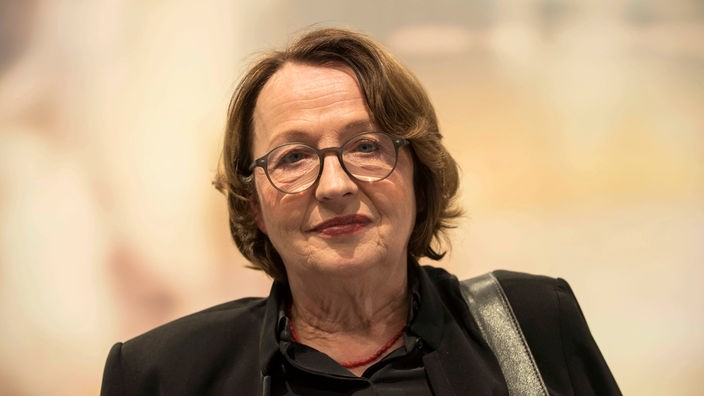 Schrifstellerin Katja Lange-Müller blickt vor orangem Hintergrund in die Kamera