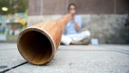 Straßenmusiker spielt auf einem Didgeridoo