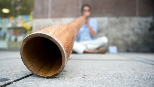 Straßenmusiker spielt auf einem Didgeridoo