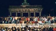 Menschen steigen in Berlin auf die Mauer nach der Öffnung 9. November 1989