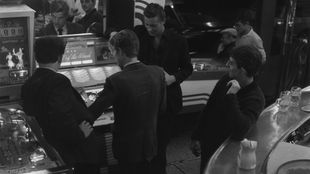 Jugendliche in einer Spielothek an einer Jukebox