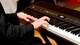Ein Musiker spielt während einer Feier auf einem E-Piano.