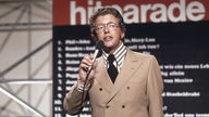 Dieter Thomas Heck <Fernsehmoderator, Deutschland> bei der Moderation der Folge 37 der ZDF-Hitparade, 1972,  redend, Mikrofon, Tafel mit Überschrift "Hitparade" im Hintergrund