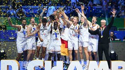 Die deutsche Basketball-Nationalmannschaft feiert mit der Trophäe den WM-Titel bei der Siegerehrung.