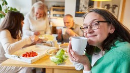Senioren sitzen zusammen in der Küche und frühstücken.