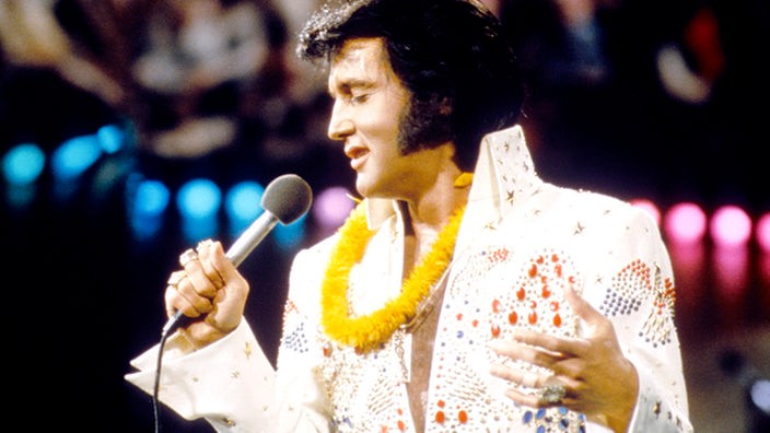 Elvis Presley bei seinem Konzert "Aloha from Hawaii" in Honolulu mit einer Blumenkette um den Hals