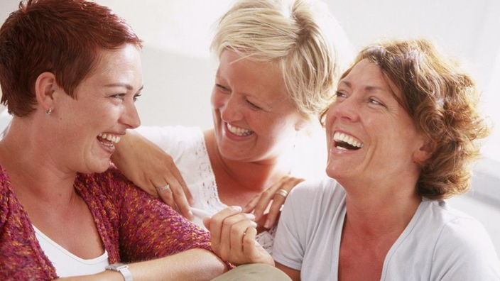 Frauen sitzen gesellig beieinander und lachen