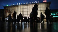 Reisende gehen nachts am Hauptbahnhof Köln vorbei