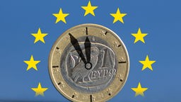  Fünf vor Zwölf für Griechenland: Uhrzeiger auf einem griechischen Euro mit Flagge der EU 