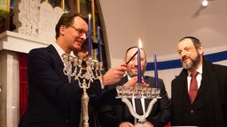 NRW-Ministerpräsident Hendrik Wüst entzündet am 07.12.2023 in der jüdischen Gemeinde Düsseldorf die erste Chanukka-Kerze
