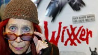 Schauspielerin Eva Ebner vor einem Filmplakat von "Der Wixxer"
