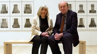 Industriefotografin Hilla Becher mit ihrem Mann sitzend auf Bank