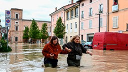 Fußgänger gehen nach sintflutartigen Regenfällen auf einer überfluteten Straße in Castel Bolognese, Italien, 17.05.2023.