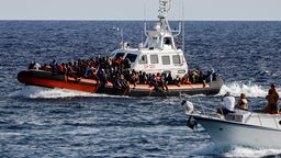 Italienische Küstenwache mit auf See geretteten Migranten auf der sizilianischen Insel Lampedusa, Italien, 18.09.2023. 