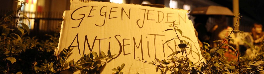 Mahnwache vor der Synagoge in Berlin-Kreuzberg: Plakat mit Aufschrift "Gegen jeden Antisemitismus" 