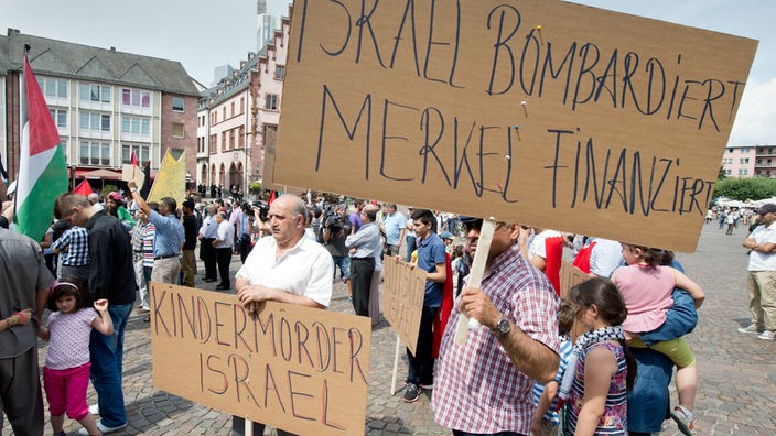 Auf einer pro-palästinensischen Demonstration in Frankfurt am Main, halten Demonstranten unter anderem Plakate mit Parolen, wie "Kindermörder Israel", welche auf die antisemitische Ritualmordlegende zurückgehen.