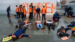 Polizei fesselt Aktivisten und Aktivistinnen der Letzten Generation mit Handschellen nach Farbattacke auf das Bundeskanzleramt