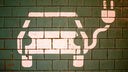 Ein Symbol markiert einen Parkplatz mit einer öffentlichen Ladesäule für Elektroautos.