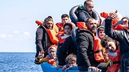 Gerettete Flüchtlinge auf einem Holzboot auf dem Mittelmeer (16.03.2024).