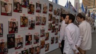 Israelis betrachten Fotos von Menschen, die im Gazastreifen vermisst und gefangen gehalten werden (20.10.2022).