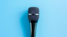 Symbolbild: Ein Mikrophon vor blauem Hintergrund