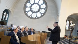 Vertreter von vier muslimischen Verbänden hören in der Kölner Synagoge dem Vorstand der Synagogen-Gemeinde, Abraham Lehrer (r), zu