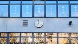 Symbolbild: Die Uhr an einem Schulgebäude zeigt 07:59 Uhr an (Berlin 2021).