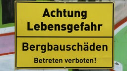 Schild an einem Tor warnt vor Bergbauschaeden, Achtung Lebensgefahr, Bergbauschaeden. Betreten Verboten, 