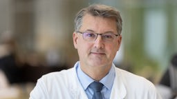 Eine Porträtaufnahme von Prof. Dr. Christopg Lübbert mit Brille und in Arztkittel.