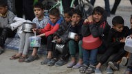 Vertriebene Palästinenser sammeln vor einer Iftar-Mahlzeit von einer Wohltätigkeitsorganisation gespendete Lebensmittel ein