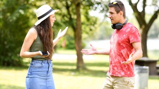 Ein junges Paar streitet sich in einem Park. 
