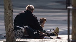 Obdachloser mit Hund auf der Straße