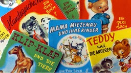 Die acht Bände der ersten Serie Pixi-Büche aus dem Jahr 1954 liegen übereinander.