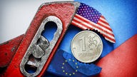Ein Rubel Münze vor russischer Fahne in der Zange von USA und EU